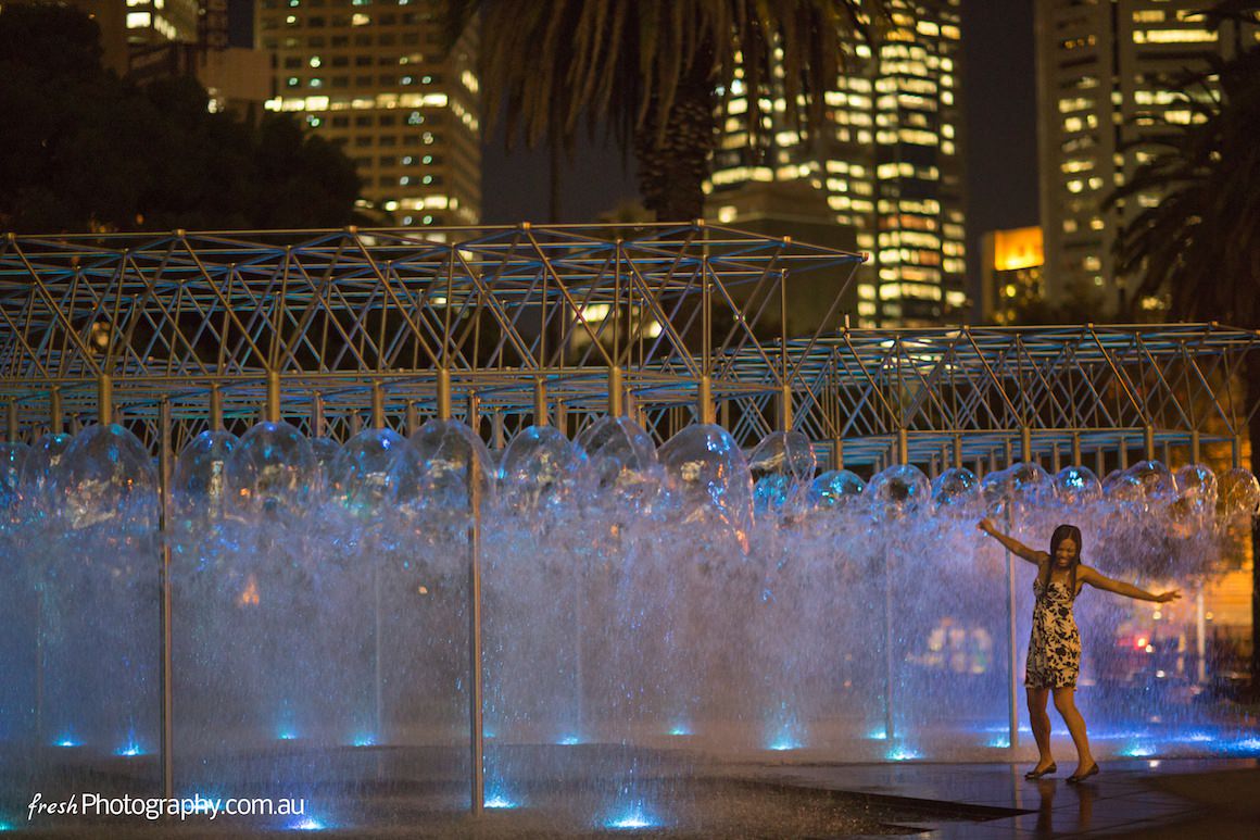 Girl dancing in fountain in the Melbourne CBD at night - enjoy Melbourne - the most liveable city in the world