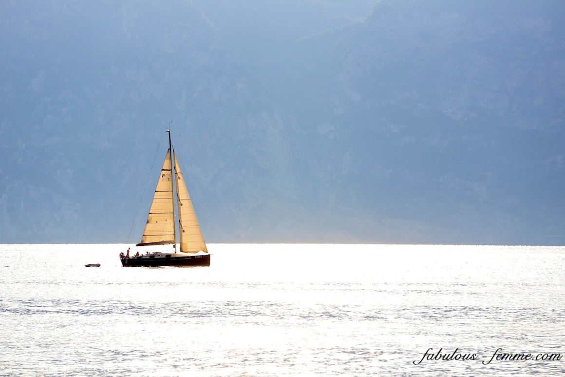 sailing boat on lake garda, italy - backlit