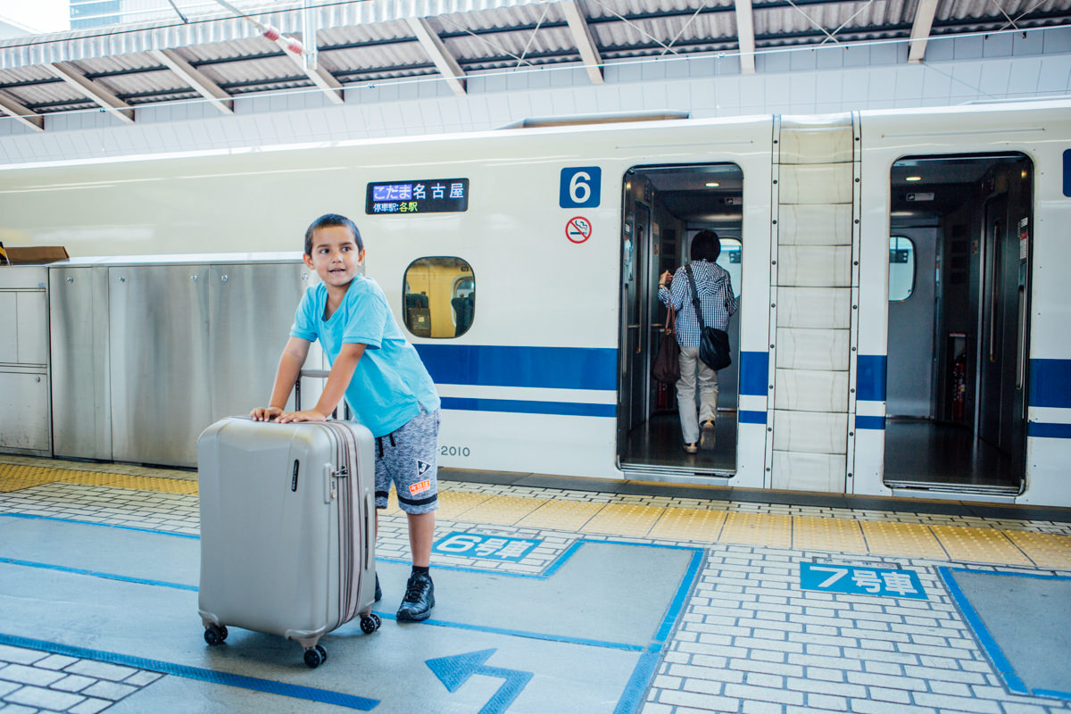 Little boy carries suitcase - travel in japan on the shinkansen high speed train