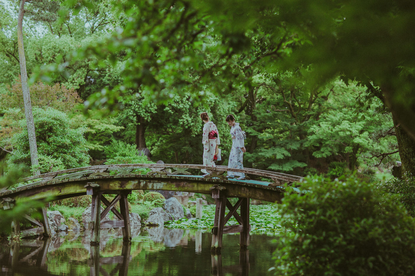 geishas in japanese garden on bridge