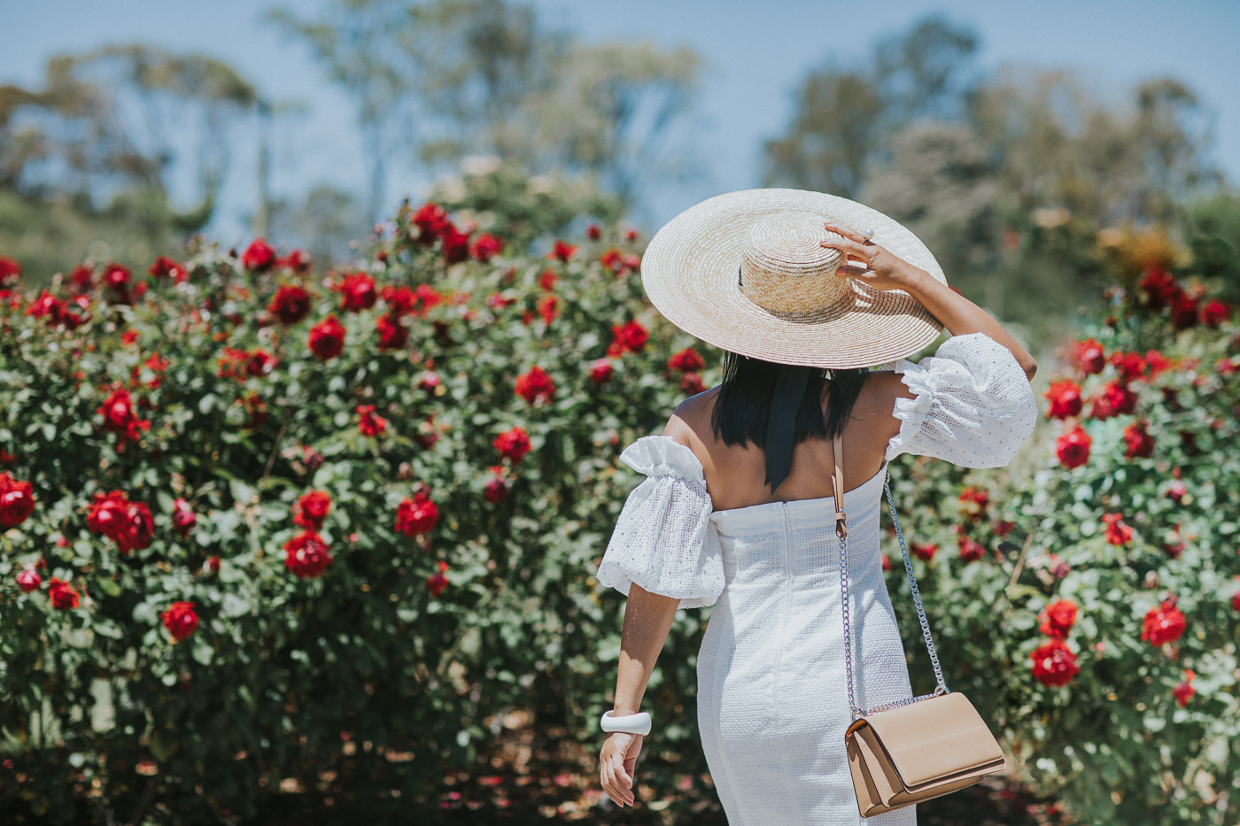 girl from back not showing face with large hat and roses